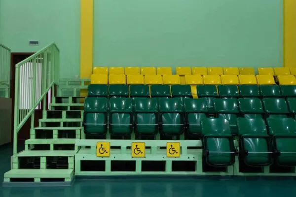 Green and yellow seats and seats for the disabled. Seating seats sports hall. Copy space. Territory without people. | Making Sport a Spectacle for all to See