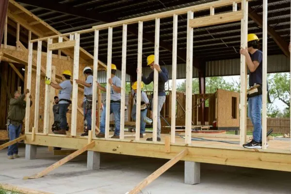 Construction workers at a manufacturing site known as “the farm” in Brownsville, Texas, assemble the modular housing innovation MiCASiTA, developed by Housing Affordability Breakthrough Challenge winner cdcb | come dream. come build. in partnership with buildingcommunityWORKSHOP. The sustainable rural homeownership innovation allows families to “grow” the size of their home as their finances and dreams evolve. 
CREDIT: Brenda Bazán/Enterprise Community Partners | NATIONAL BUILDING MUSEUM ANNOUNCES MAJOR NEW EXHIBITION EXPLORING HOW HOUSING AFFORDABILITY INNOVATIONS CAN BECOME REAL WORLD SOLUTIONS